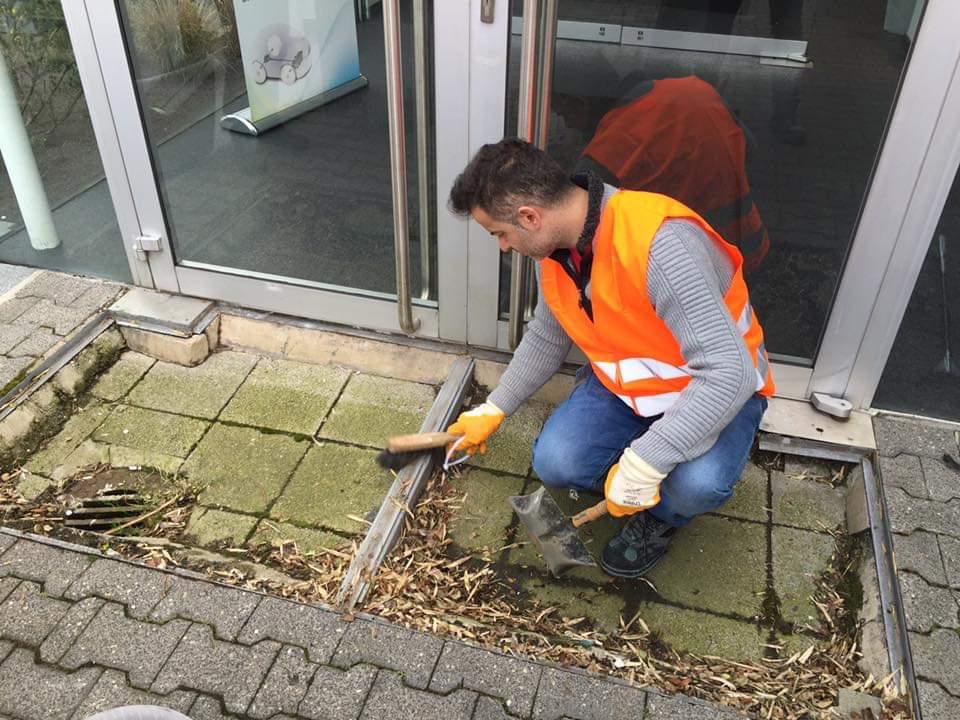Reinigungskräfte von Oenal Gebäudreinigung aus Obertshausen fegen den Boden