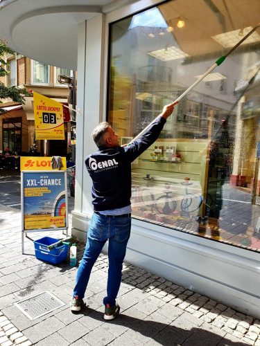 Mitarbeiter von der Oenal Gebäudereinigung in Obertshausen reinigt die Fenster von einem Kiosk
